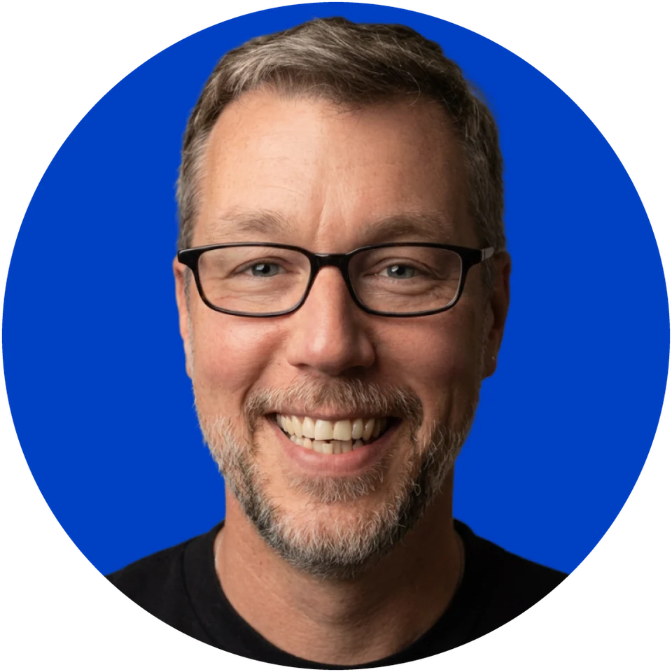 A circular portrait of Joshua W. Frappier, founder of Wellstone Collective, smiling against a cobalt background.