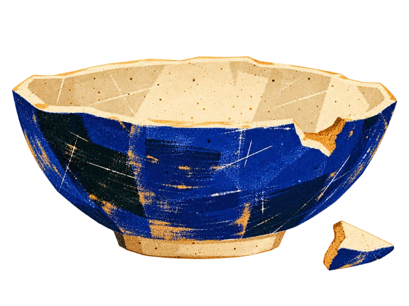 A blue ceramic bowl with a broken notch in its cream rim and the loose shard beside it.
